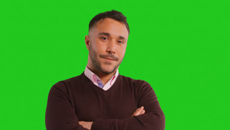 Close-Up-Studio-Portrait-Of-Male-Teacher-Or-Businessman-Standing-Against-Green-Screen-Folding-Arms