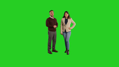 Full-Length-Studio-Portrait-Of-Smiling-Male-And-Female-Teachers-Or-Businesspeople-Standing-Against-Green-Screen-Background