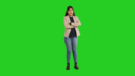 Full-Length-Studio-Portrait-Of-Female-Teacher-Or-Businesswoman-Standing-Against-Green-Screen-Folding-Arms