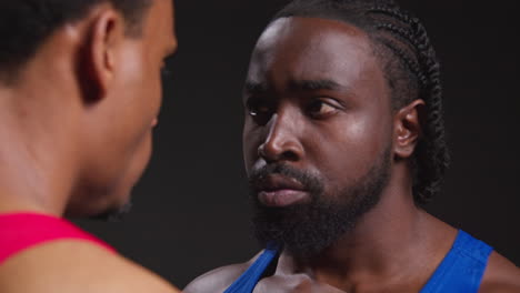 Close-Up-Of-Male-Boxer-And-Opponent-Standing-Face-To-Face-Before-Boxing-Match-Staring-At-Each-Other-2