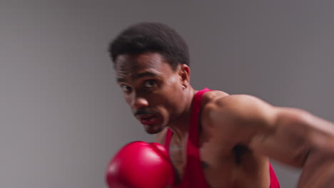 Toma-De-Estudio-En-Tiempo-Real-De-Un-Boxeador-Con-Guantes-De-Boxeo-En-Una-Pelea-De-Boxeo-Y-Golpeando-Hacia-La-Cámara-4