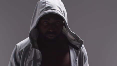 Close-Up-Portrait-Of-Male-Boxer-With-Hands-Wrapped-In-Protective-Bandages-Training-For-Boxing-Match-Against-Grey-Background