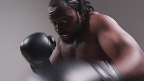 Toma-De-Estudio-En-Tiempo-Real-De-Un-Boxeador-Con-Guantes-De-Boxeo-En-Una-Pelea-De-Boxeo-Y-Golpeando-Hacia-La-Cámara-1