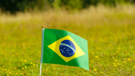 Close-Up-Of-Small-Brazilian-National-Flag-Outdoors-In-Countryside-Field-Or-Garden-Moving-In-Wind-1