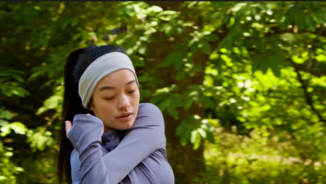 Mujer-Joven-Estirándose-Antes-De-Hacer-Ejercicio-Corriendo-Por-El-Parque-De-La-Ciudad-Con-Auriculares-Inalámbricos-4