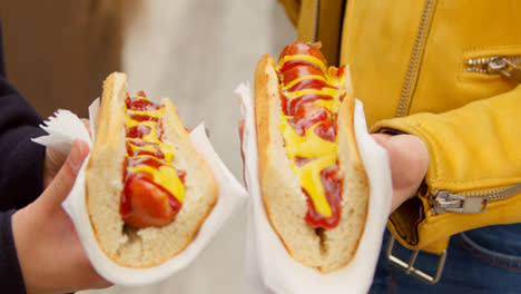 Close-Up-Of-Two-Women-Buying-Hot-Dogs-From-Street-Food-Market-Stall-2