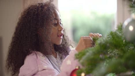 Child-Hanging-Bauble-on-Christmas-Tree