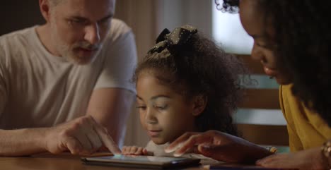 Niño-and-Parents-Using-a-Tablet