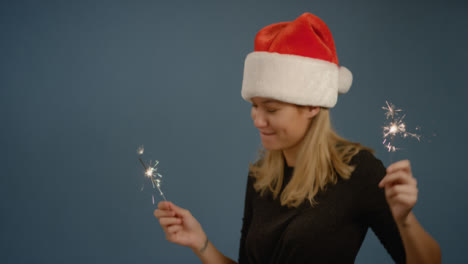 Dancing-Woman-wearing-Santa-Hat-with-Sparklers