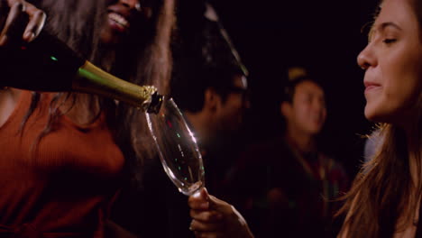 Young-Woman-Pours-Champagne-at-Party