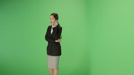 Businesswoman-walking-and-talking-on-phone-with-green-screen