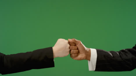 CU-Colleagues-in-suits-fist-bump-explosion-on-green-screen