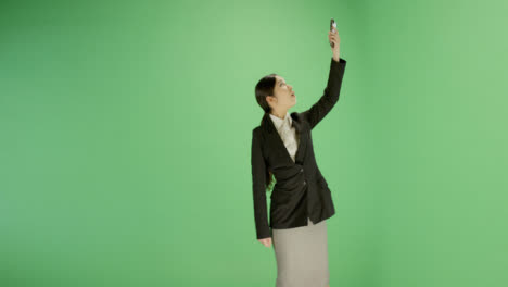 Businesswoman-trying-find-phone-signal-on-green-screen