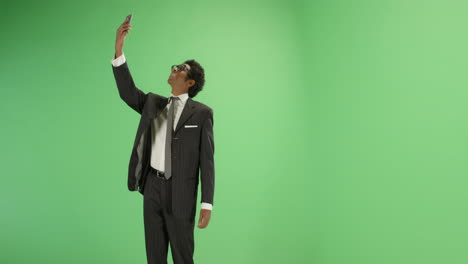 Businessman-finding-phone-signal-on-green-screen
