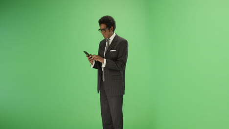 Businessman-takes-out-phone-and-texts-on-green-screen