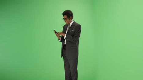 Smiling-man-sending-message-on-phone-with-green-screen