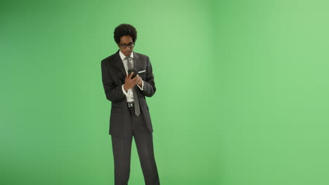 Happy-businessman-typing-on-phone-with-green-screen