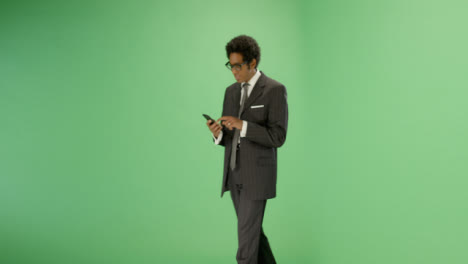 Empresario-enviando-mensajes-de-texto-mientras-camina-en-la-pantalla-verde
