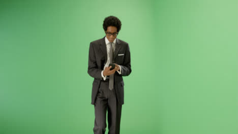 Texting-Businessman-walking-towards-camera-on-green-screen