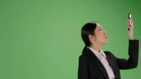 Low-Angle-Woman-finding-phone-signal-on-green-screen