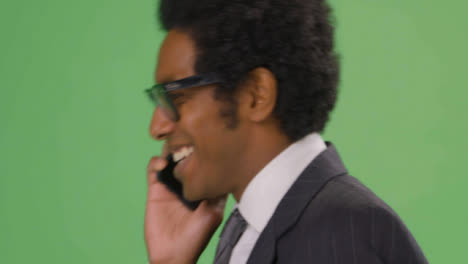 CU-Happy-Businessman-walking-and-talking-on-teléfono-with-green-screen