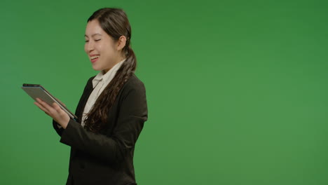 Happy-Businesswoman-Uses-Tablet-on-Green-Screen