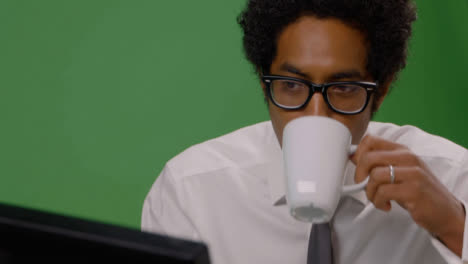 CU-Businessman-Sips-Drink-and-Working-on-Computer