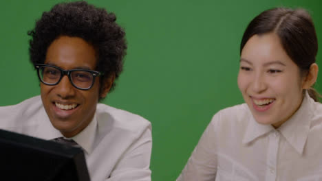 CU-Colleagues-looking-at-Computer-Smiling-on-Green-Screen