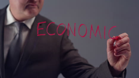 Businessman-Writing-Word-Economics