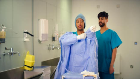 Medical-Staff-Putting-On-Surgical-Gown