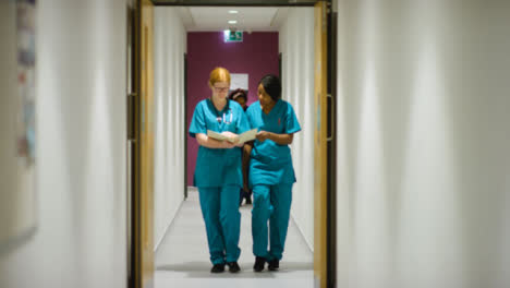 médico-Staff-Walking-Through-Hospital