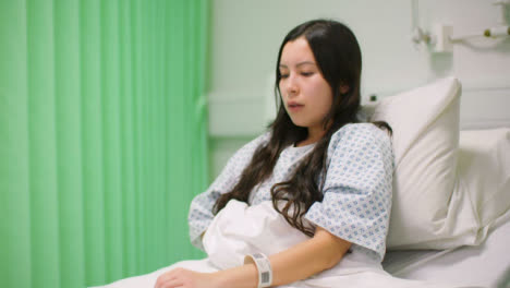 Female-Patient-Coughing-in-Hospital-Bed