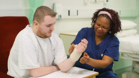 Krankenschwester-Bandagiert-Patienten-Verletztes-Handgelenk
