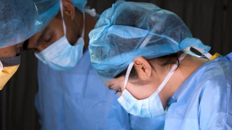 CU-Tres-cirujanos-miran-hacia-abajo-en-la-cirugía