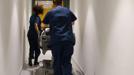médico-staff-pushing-patient-in-hospital-bed