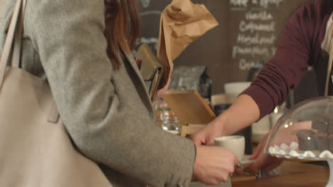 Woman-Being-Served-Coffee-in-Cafe