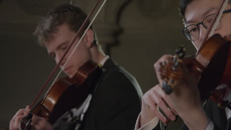 Panning-Close-Up-Three-Violinists-Playing-Together