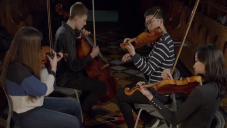 Inclinarse-hacia-abajo-en-el-cuarteto-de-cuerda-tocando-durante-el-ensayo