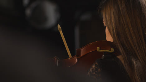 Vista-trasera-Pan-de-violinista-femenina-durante-la-actuación