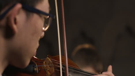 Close-Up-Pan-Up-Of-Male-Violinist-During-Performance