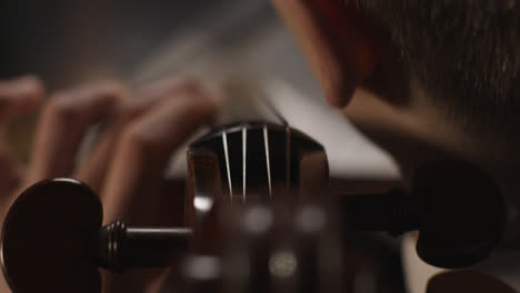 Sobrecarga-cerca-del-violonchelista-masculino-tocando-el-violonchelo