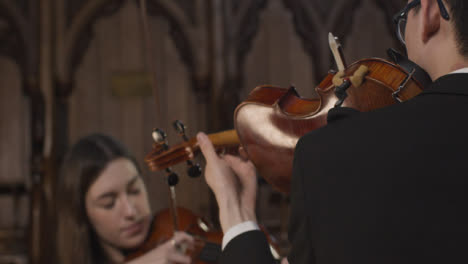 Vista-trasera-del-violinista-masculino-realizando