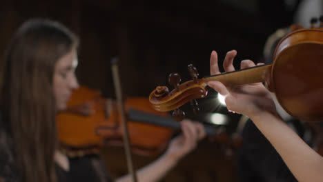 Dos-mujeres-violinistas-tocando-en-una-actuación
