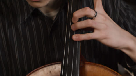 Cerca-de-violonchelista-masculino-jugando