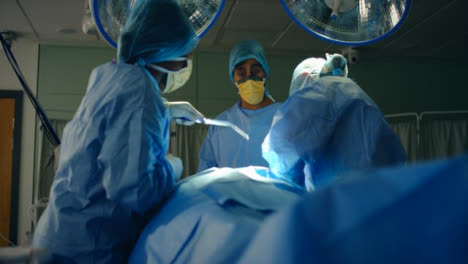 Low-Pan-médico-Staff-Picks-Up-Suction-Machine-During-Surgery