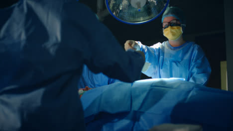 Chirurg-übergibt-Skalpell-An-Assistentin-Zurückhaltend