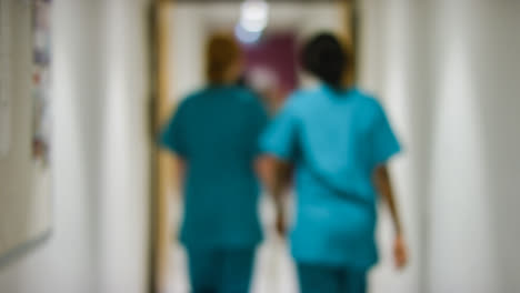 Blurred-Medical-Staff-Walking-Away--In-Hospital-Corridor