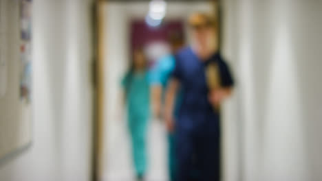 Blurred-Medical-Staff-Walking-Towards--In-Hospital-Corridor