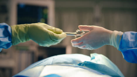 Instrumento-médico-que-pasa-la-mano-CU-sobre-la-cama-operativa