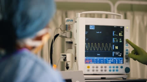 Surgeon-Pressing-Button-on-Heart-Rate-Monitor